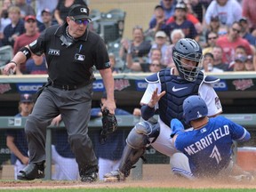 Blue Jays second baseman Whit Merrifield (1) is initially called out by umpire Marty Foster (left) at the plate on a tag by Twins catcher Gary Sanchez during the 10th inning at Target Field in Minneapolis, Sunday, Aug 7, 2022. The call was challenged by the Blue Jays and overturned, ruling Merrifield safe on the play due to the catcher blocking the plate.