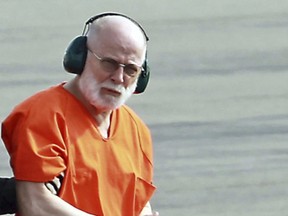 FILE - In this June 30, 2011 file photo, James "Whitey" Bulger, right, is escorted from a U.S. Coast Guard helicopter to a waiting vehicle at an airport in Plymouth, Mass., after attending hearings in federal court in Boston. Three years after he was bludgeoned to death in a West Virginia prison, no one has been charged in the beating death of murderous Boston crime boss James "Whitey" Bulger. Bulger was 89 when he was fatally beaten in October 2018. (Stuart Cahill/The Boston Herald via AP, File)