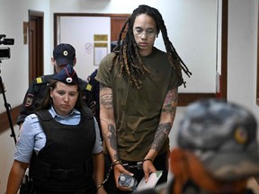 US basketball player Brittney Griner is escorted by police before a hearing during her trial on charges of drug smuggling, in Khimki, outside Moscow on August 2, 2022.