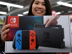 This file photo taken on March 3, 2017 shows 31-year-old Nao Imoto posing with her newly purchased Nintendo Switch game console at a shop in Tokyo.