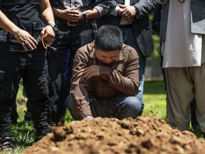 Altaf Hussain cries over the grave of his brother, Aftab Hussein, at Fairview Memorial Park in Albuquerque, N.M., on Friday, Aug. 5, 2022.