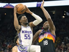 Sacramento Kings guard Josh Jackson (55) drives on Phoenix Suns center Bismack Biyombo during the first half of an NBA basketball game, Sunday, April 10, 2022, in Phoenix.