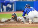 Jorge Mateo of the Baltimore Orioles slides under the tag of Danny Jansen of the Toronto Blue Jays at Rogers Centre on August 15, 2022 in Toronto. 