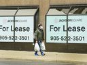 A man walks past office rental signs during the COVID-19 pandemic in downtown Hamilton, Ont., Thursday, March 18, 2021.