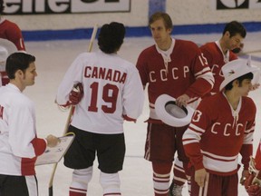 Team Canada Players give white Stetson hats to Russian players as part of a souvenir exchange.