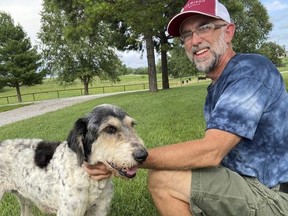 This image provided by Jeff Bohnert and taken by his wife, Kathy Bohnert, shows him and his dog, Abby, in August 2022.