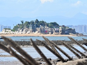 A Taiwanese military outpost on Shihyu islet is seen past anti-landing spikes placed along the coast of Lieyu islet on Taiwan's Kinmen islands, which lie just 3.2 km from the mainland China coast, on Aug. 10, 2022.