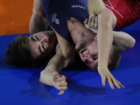 Canada's McNeil Lachlan, left, wrestles with Scotland's Connelly Ross during Men's freestyle match at the Commonwealth Games, in Birmingham, England, Friday, Aug. 5, 2022.