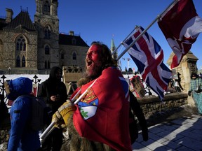 A protester yells “freedom” towards a person who attempted to stick a paper sign on a truck criticizing the so called “Freedom Convoy,” a protest against COVID-19 measures that has grown into a broader anti-government protest, on its 18th day, in Ottawa, Feb. 14, 2022.