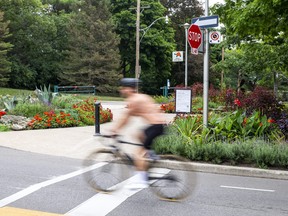 A cyclist goes through an intersection with out stopping at High Park in Toronto, Ont. on Thursday, Aug. 4, 2022.