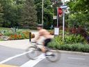 Ein Radfahrer fährt über eine Kreuzung, ohne am High Park in Toronto, Ontario, anzuhalten.  am Donnerstag, 4. August 2022.