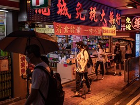 Pedestrians walk past a pharmacy with a closing sale on August 5, 2022 in Hong Kong, China.