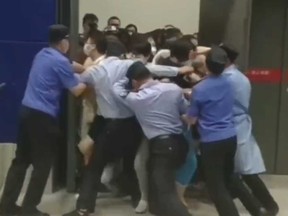 IKEA security guards and health workers in personal protective equipment tried to close a door to prevent people from exiting the store in Shanghai as it was being locked down due to a COVID-19 exposure.