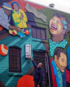 An Attucks Adams guide tells stories near the “D.C. Jazz Heroes” mural by Kate DeCiccio and Rose Jaffe. (Tim Wright)