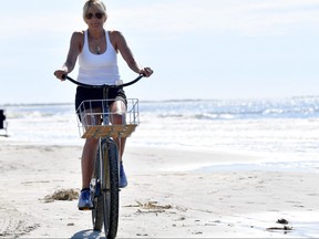 U.S. first lady Jill Biden rides her bicycle along the beach while on vacation in Kiawah Island, S.C., on Aug. 14, 2022.