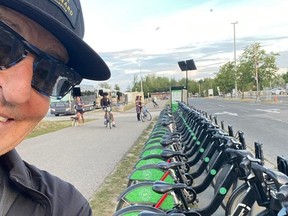 Selfie of REO Speedwagon band member Kevin Cronin and row of rental bikes in Toronto.