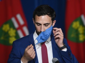 Ontario Education Minister Stephen Lecce takes his mask off before answering questions during a press conference at Queen's Park in Toronto on Wednesday, June 2, 2021.