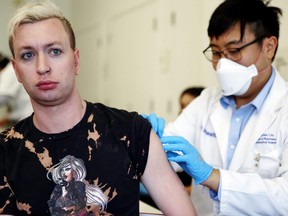 Student pharmacist Charles Liu (right) prepares to administer a dose of the monkeypox vaccine to a person at a pop-up vaccination clinic by the Los Angeles County Department of Public Health at the West Hollywood Library in West Hollywood, Calif., Aug. 3, 2022.