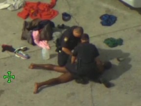 Naked man lying face down on ground after deputies arrive to arrest him.
