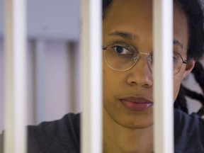 U.S. Basketball player Brittney Griner looks through bars as she listens to the verdict standing in a cage in a courtroom in Khimki, outside Moscow, Russia, Thursday, Aug. 4, 2022.
