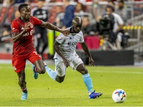 Aug 17, 2022; Toronto, Ontario, CAN; Toronto FC defender Richie Laryea (19) battles for the ball against New England Revolution midfielder Ema Boateng (11) during the second half at BMO Field.