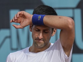 Novak Djokovic, of Serbia, wipes the sweat off during a training session at the Mutua Madrid Open tennis tournament in Madrid, Spain, on April 30, 2022.