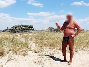Russian tourist posing in front of a Russian S-400 anti-air system.