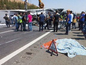 Emergency and rescue teams attend the scene after a bus crash accident on the highway between Gaziantep and Nizip, Turkey, Saturday, Aug. 20, 2022. (IHA via AP)