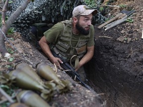 A Ukrainian soldier walks along a trench at a position along the front line in the Donetsk region, Aug. 15, 2022.