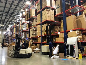 Warehouse workers deal with inventory stacked up to the ceiling at an ABT Electronics Facility in Glenview, Illinois.