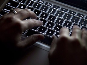 Eine Frau benutzt ihre Computertastatur zum Tippen, während sie am 19. Dezember 2012 in North Vancouver, BC, im Internet surft.