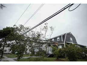 A tree rests against power lines after post-tropical Storm Fiona hit on Sept. 24, 2022 in Sydney, Nova Scotia.