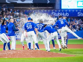 TORONTO, ON - SEPTEMBER 26: Teammates splash Vladimir Guerrero Jr. #27 of the Toronto Blue Jays with water after his walk-off hit to defeat the New York Yankees in the tenth inning during their MLB game at the Rogers Centre on September 26, 2022 in Toronto, Ontario, Canada. (Photo by Mark Blinch/Getty Images)