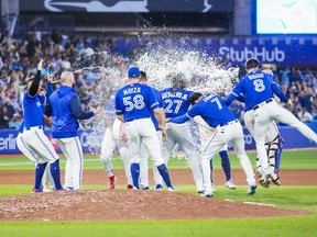 Teammates splash Vladimir Guerrero Jr. of the Toronto Blue Jays with water after his walk-off hit to defeat the New York Yankees in the 10th inning at Rogers Centre on Sept. 26, 2022 in Toronto.