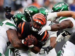 Samaje Perine of the Cincinnati Bengals runs with the ball against Diontae Spencer (L) and C.J. Mosley of the New York Jets (R) during the fourth quarter at MetLife Stadium on September 25, 2022 in East Rutherford, New Jersey.