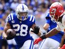 Jonathan Taylor of the Indianapolis Colts runs with the ball against Carlos Dunlap of the Kansas City Chiefs during the second half at Lucas Oil Stadium on September 25, 2022 in Indianapolis, Indiana. 