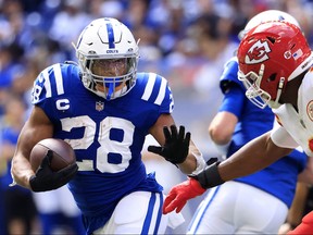 Jonathan Taylor of the Indianapolis Colts runs with the ball against Carlos Dunlap of the Kansas City Chiefs during the second half at Lucas Oil Stadium on September 25, 2022 in Indianapolis, Indiana.