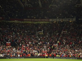 Manchester United fans observe a minutes silence following the death of Queen Elizabeth II, ahead of the group E Europa League soccer match between Manchester United and Real Sociedad at Old Trafford in Manchester, England, Thursday, Sept. 8, 2022.