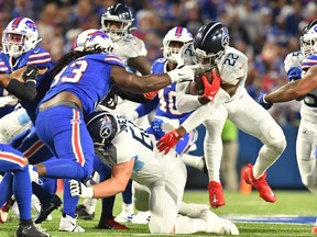 Tennessee Titans running back Derrick Henry (22) tries to avoid Buffalo Bills defensive tackle Brandin Bryant.