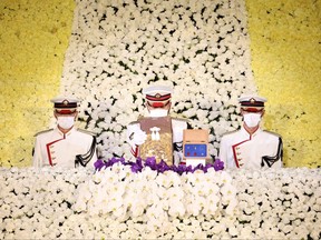 A Japanese guard, centre, holds the urn containing the ashes of former Japanese prime minister Shinzo Abe during his state funeral in the Nippon Budokan in Tokyo on Sept. 27, 2022.