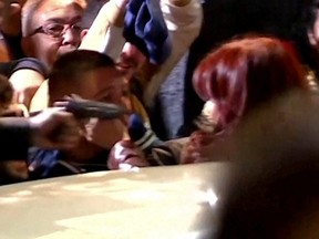 A man points a gun at Argentina's Vice President Cristina Fernandez de Kirchner, with no shots fired, at the entrance of Fernandez de Kirchner's home in Buenos Aires, Argentina, Sept. 1, 2022 in this still image taken from video.