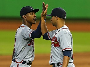 Anthony Varvaro (right) and B.J. Upton of the Atlanta Braves high five after winning a game against the Miami Marlins at Marlins Park on September 12, 2013 in Miami, Florida.