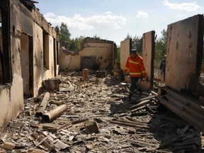 Firefighters work among the ruins of a house, which is said was hit by Azeri shelling during recent border clashes with Azerbaijan, in the settlement of Sotk, Armenia, Wednesday, Sept. 14, 2022.