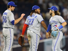 NEW YORK, NEW YORK - AUGUST 18: Vladimir Guerrero Jr. #27, Jordan Romano #68 and Bo Bichette #11 of the Toronto Blue Jays celebrate after defeating the New York Yankees 9-2 at Yankee Stadium on August 18, 2022 in New York City. (Photo by Mike Stobe/Getty Images)