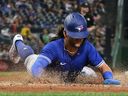 Toronto Blue Jays shortstop Bo Bichette (11) slides off home plate to score a run against the Pittsburgh Pirates in the fourth inning at PNC Park.
