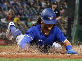 Toronto Blue Jays shortstop Bo Bichette (11) slides across home plate to score a run against the Pittsburgh Pirates during the fourth inning at PNC Park.