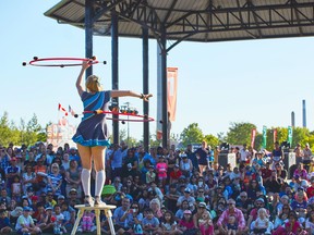 performance featuring woman with hula hoops in front of large crowd.