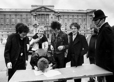 British group the Sex Pistols sign a new recording contract outside Buckingham Palace in London, 1977.