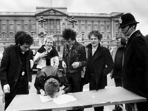 British group the Sex Pistols sign a new recording contract outside Buckingham Palace in London, 1977.