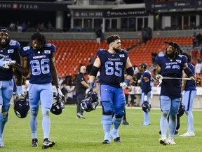 Toronto Argonauts offensive lineman Shane Richards (68), wide receiver Damonte Coxie (86), offensive lineman Dariusz Bladek (65) and  linebacker Wynton McManis (48) celebrate after defeating the Hamilton Tiger-Cats 37-20 in CFL football action in Toronto on Friday, August 26, 2022.